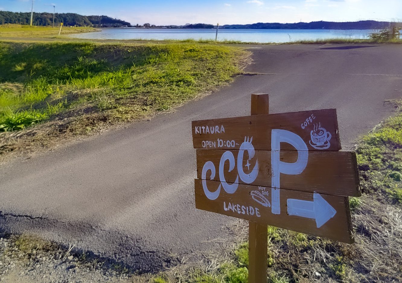 湖畔を散策する人や旅を出迎えるサイン看板。お洒落で温かみがある。