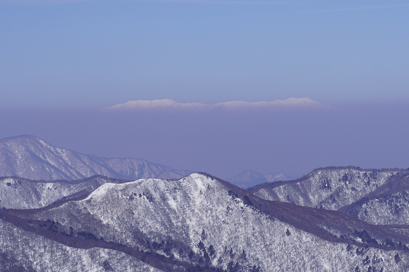 甲子旭岳の奥に浮かび上がるのが「飯豊連峰」
